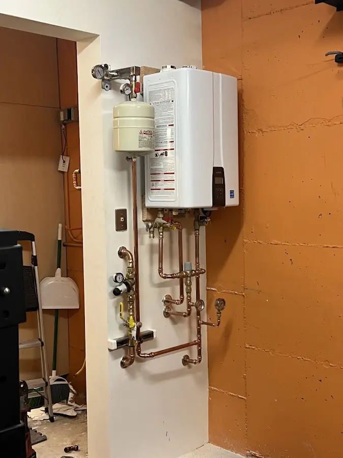 Plumbing technician inspecting water heater connections in Palo Cedro